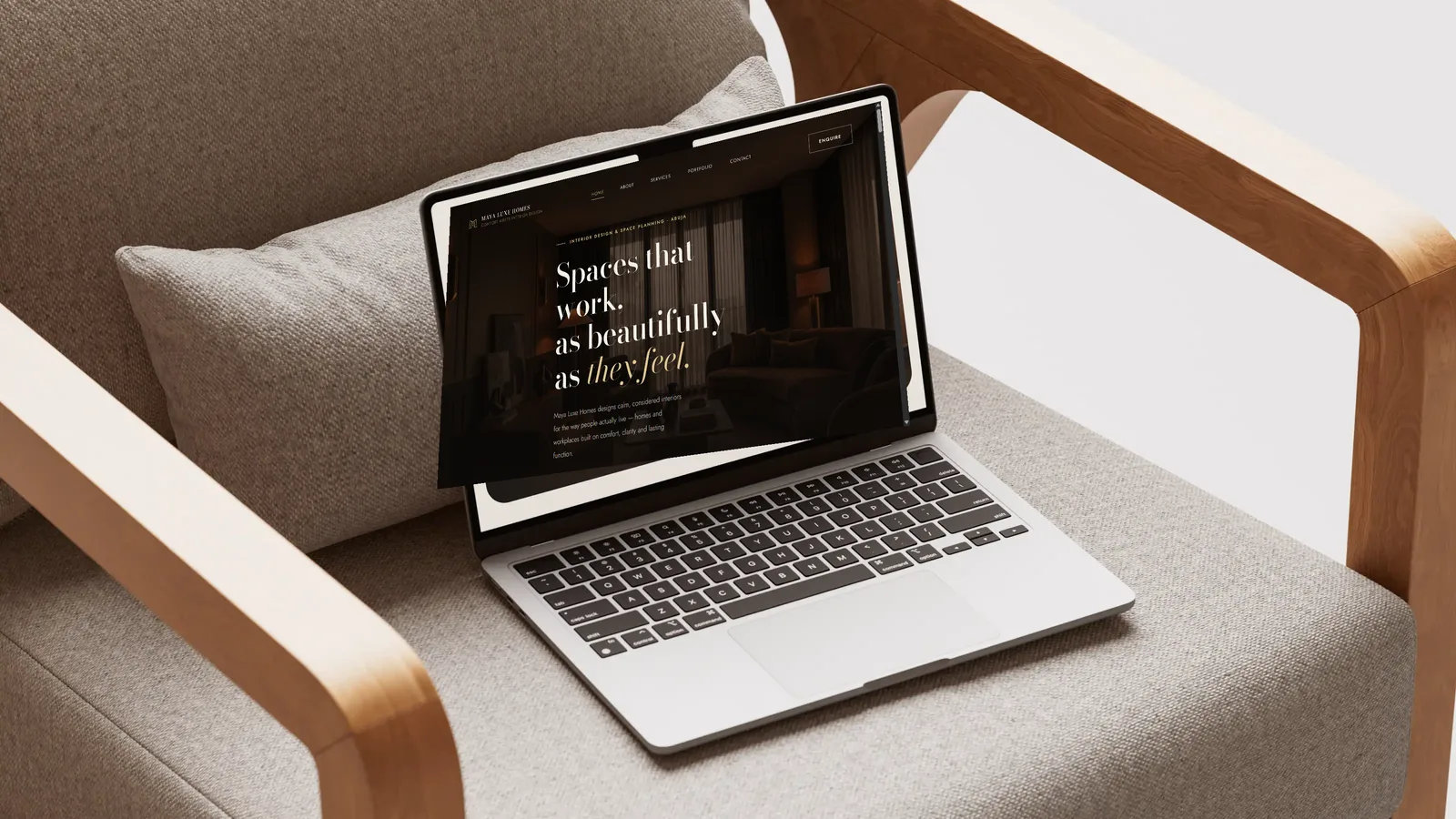 Laptop on an armchair showing the Maya Luxe Homes website homepage